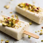 Mango kulfi mixture being stirred in a pan with milk and mango pulp.