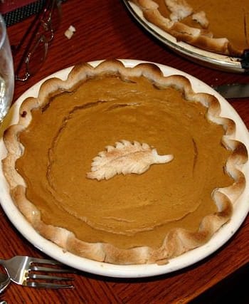 Fresh pumpkin pieces, spices, and baking ingredients prepared on a kitchen counter for a pumpkin recipe.