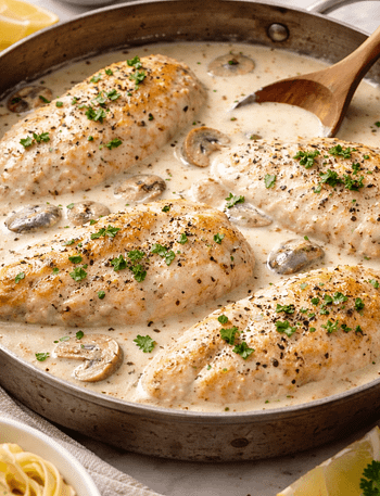 Bowl of creamy white chicken chilli topped with herbs and served warm.
