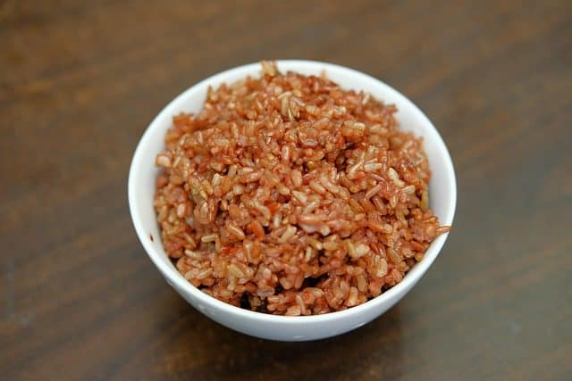 Step-by-step cooking process of Chinese Sticky Rice with glutinous rice, soy sauce, Chinese sausage, and mushrooms in a wok.