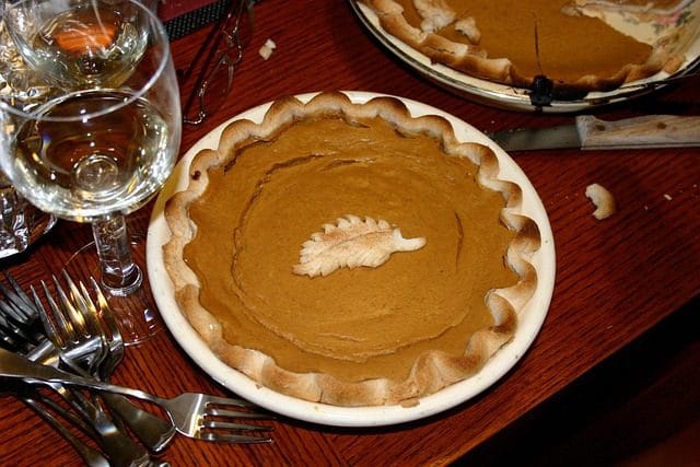 Fresh pumpkin pieces, spices, and baking ingredients prepared on a kitchen counter for a pumpkin recipe.