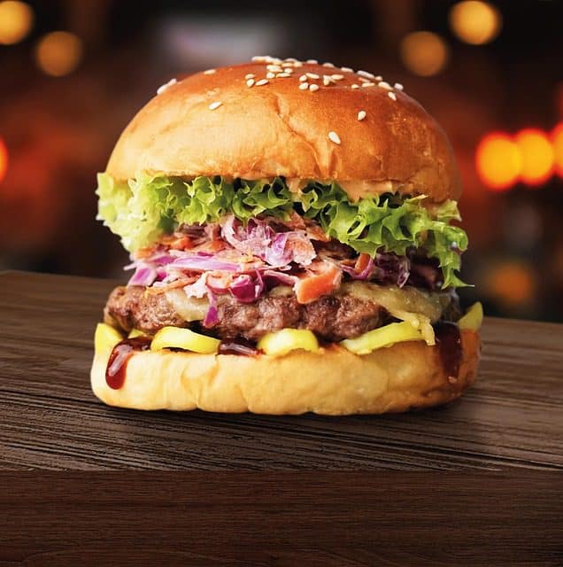 Close-up view of a classic cheeseburger showing melted cheese and fresh toppings
