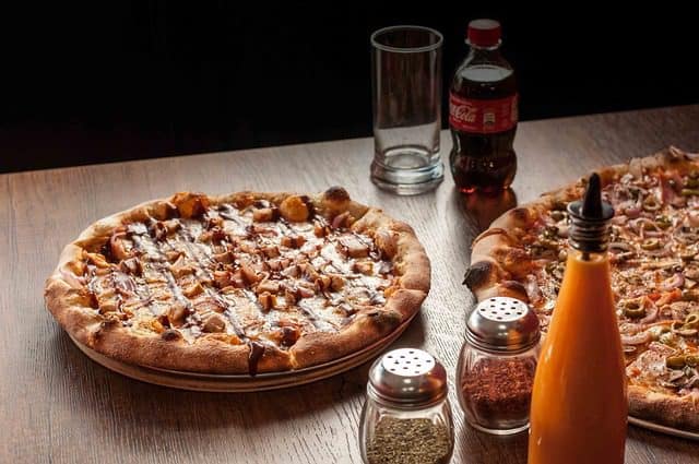 Served Tandoori Chicken Pizza on a wooden board ready for family or party